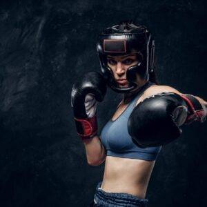 Portrait of nice female boxer at dark photo studio